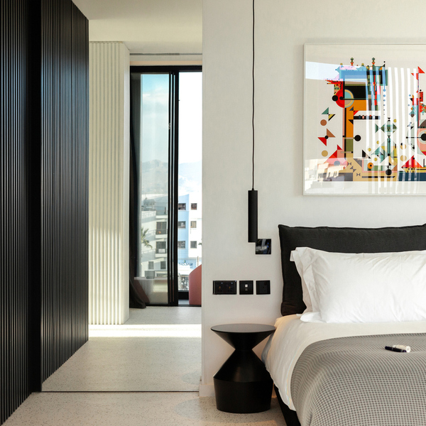 Modern room at the first smart boutique hotel in Nicosia, Cyprus, with a design bed, bold geometric artwork and a balcony overlooking the city